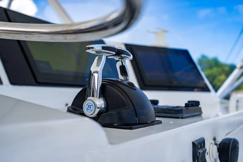 Slide: The Image of Control panel of a 1998 Bertram Convertible yacht with throttle levers and navigation screens. - 18