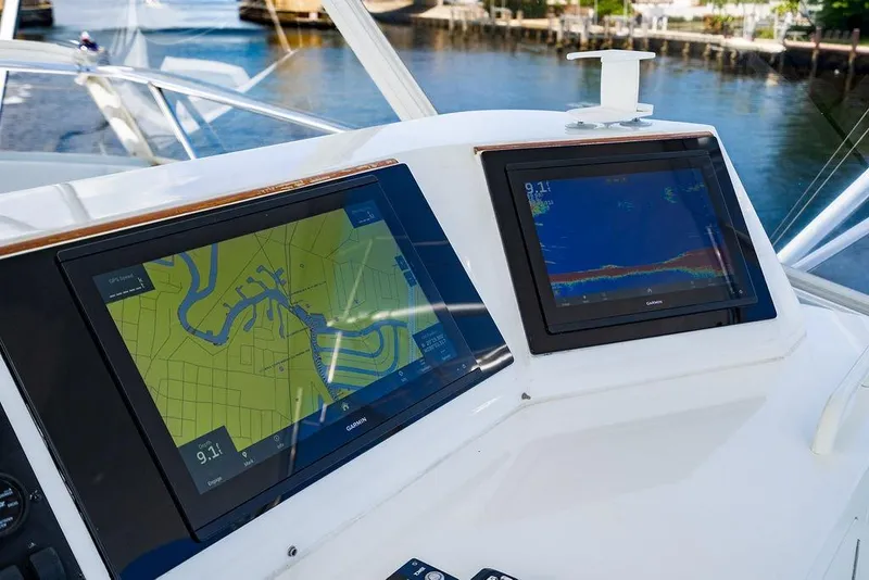 Slide: The Image of 1998 Bertram Convertible boat dashboard with dual Garmin navigation screens, dockside view. - 19