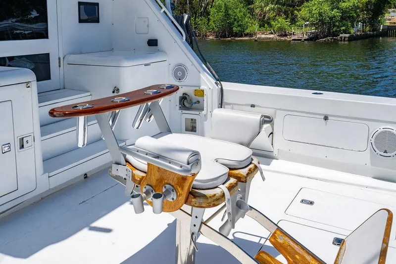 Slide: The Image of 1998 Bertram Convertible boat interior with fishing chair, rod holders, and water view. - 24