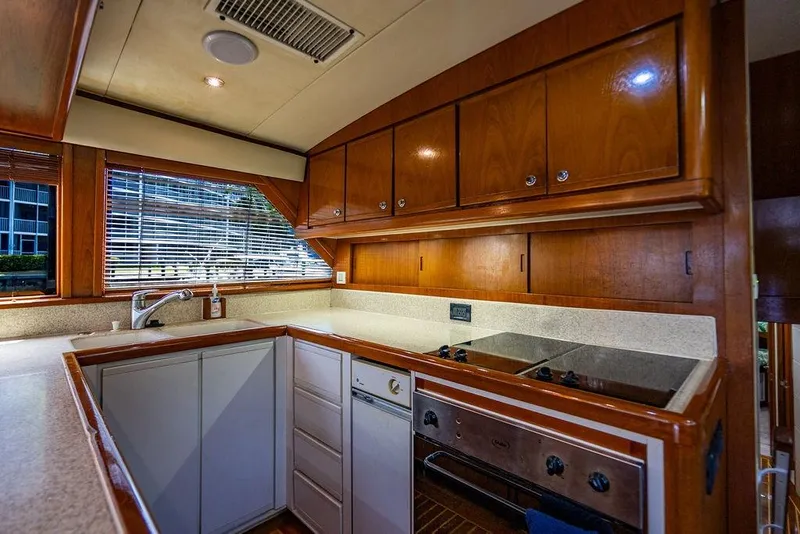 Slide: The Image of 1998 Bertram Convertible yacht kitchen with wooden cabinets and modern appliances. - 34