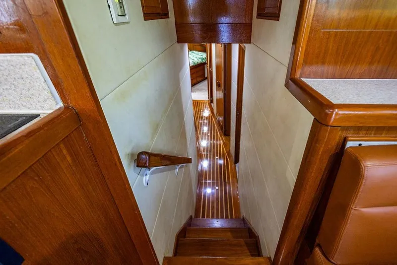 Slide: The Image of Interior of 1998 Bertram Convertible yacht with polished wood and illuminated hallway. - 42