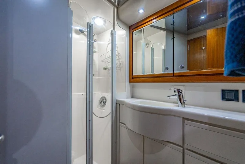 Slide: The Image of Luxurious bathroom in a 1998 Bertram Convertible yacht with modern fixtures and mirrored cabinets. - 44
