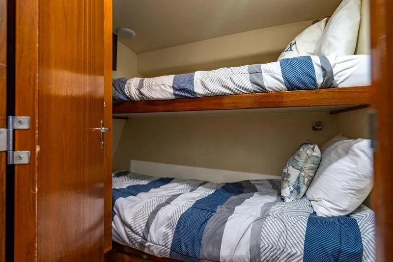 Slide: The Image of Bunk beds in a 1998 Bertram Convertible yacht cabin with striped bedding. - 51