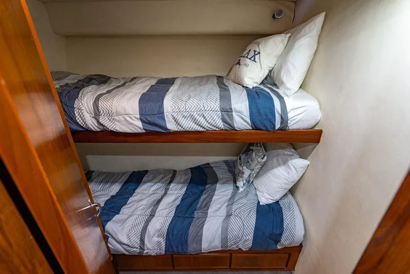 Slide: The Image of Bunk beds in a 1998 Bertram Convertible yacht cabin with striped bedding. - 52