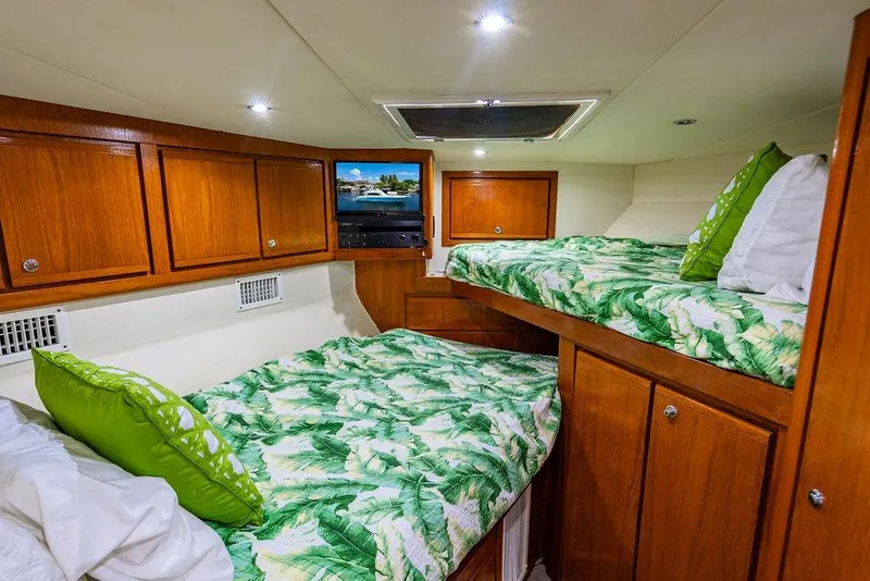 Slide: The Image of Cozy cabin interior of 1998 Bertram Convertible with wooden cabinets and tropical bedding. - 54