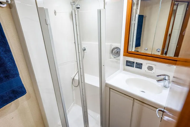 Slide: The Image of Compact bathroom in a 1998 Bertram Convertible yacht with shower and sink. - 56
