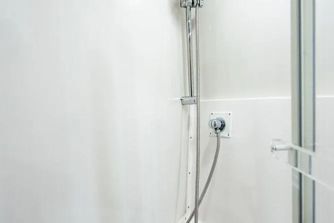 Slide: The Image of Shower area in 1998 Bertram Convertible boat, featuring sleek chrome fixtures. - 57