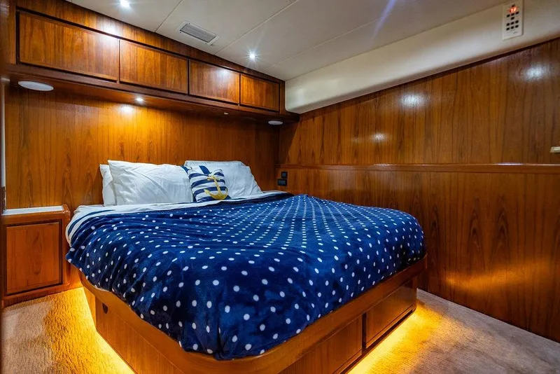 Slide: The Image of Luxurious 1998 Bertram Convertible yacht bedroom with wood paneling and cozy bedding. - 61