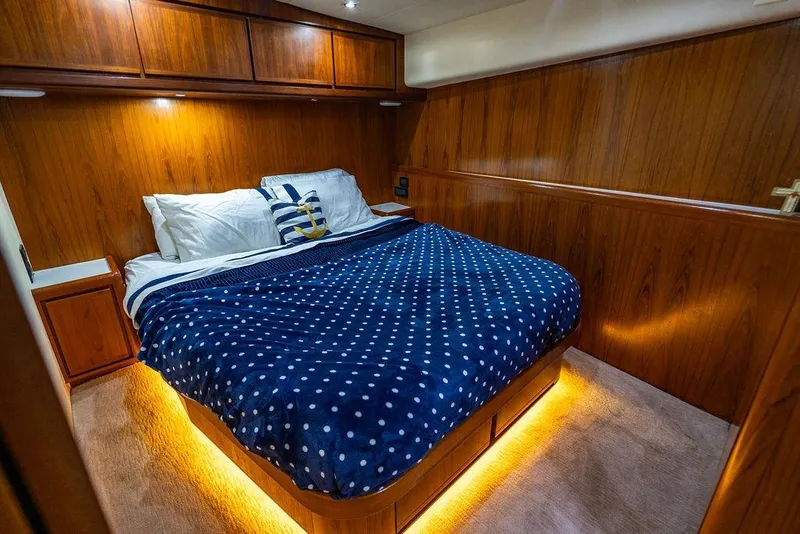 Slide: The Image of Luxurious cabin interior of a 1998 Bertram Convertible yacht with cozy bedding. - 62