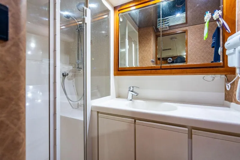 Slide: The Image of 1998 Bertram Convertible yacht bathroom with shower, sink, and mirrored cabinet. - 64