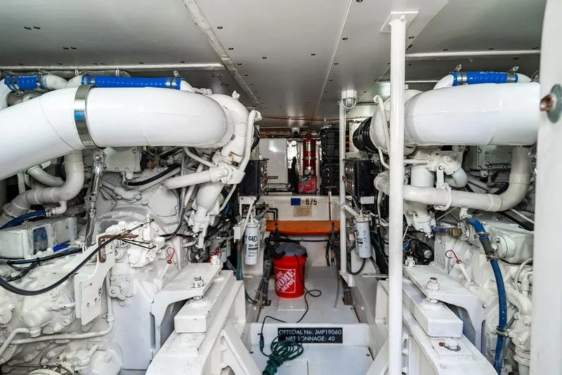 Slide: The Image of Engine room of a 1998 Bertram Convertible boat, showcasing dual engines and mechanical components. - 68