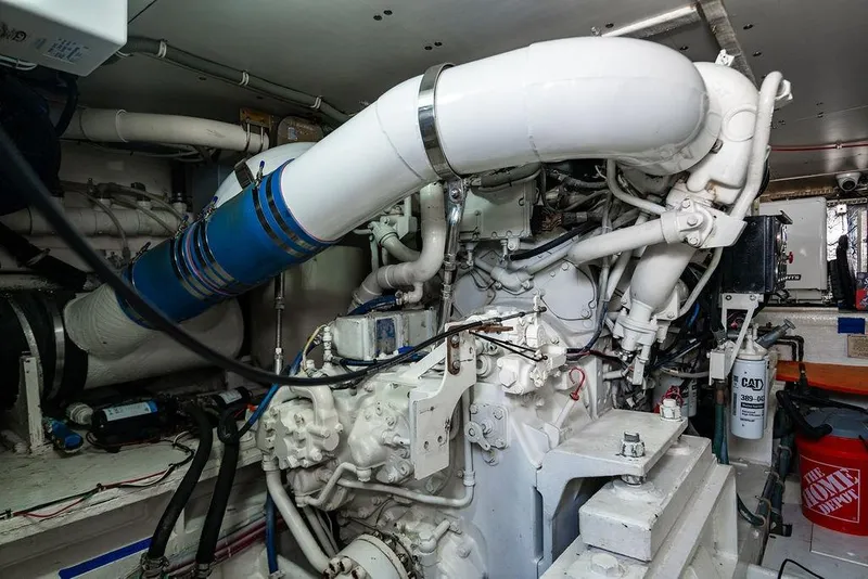 Slide: The Image of Engine room of a 1998 Bertram Convertible yacht, showcasing complex machinery and piping. - 70