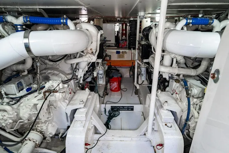 Slide: The Image of Engine room of a 1998 Bertram Convertible yacht with complex machinery and piping. - 71