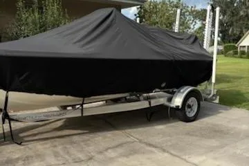 Slide: The Image of 2009 Key West 188 Bay Reef boat covered on a trailer in a driveway. - 9