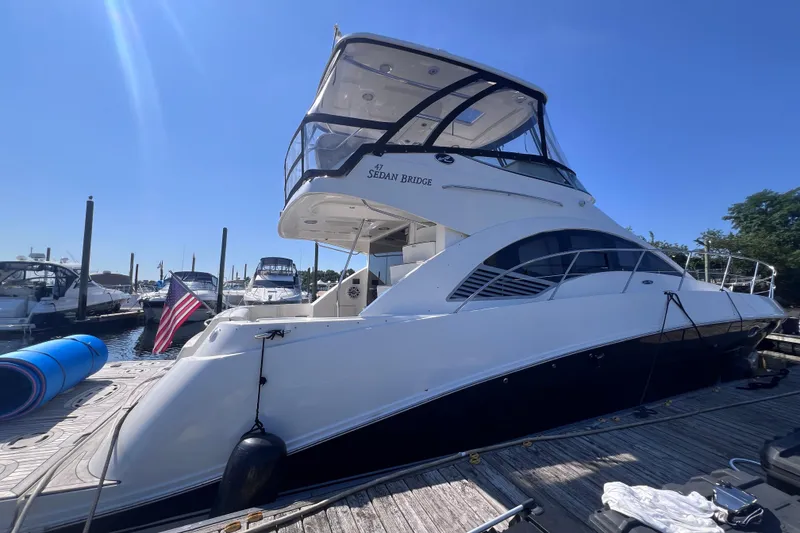 The Image of 2008 Sea Ray 47 Sedan Bridge yacht docked at marina under clear blue sky. - 0