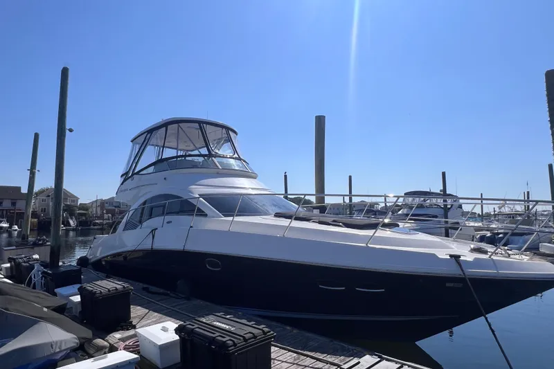 Slide: The Image of 2008 Sea Ray 47 Sedan Bridge yacht docked at marina under clear blue sky. - 1