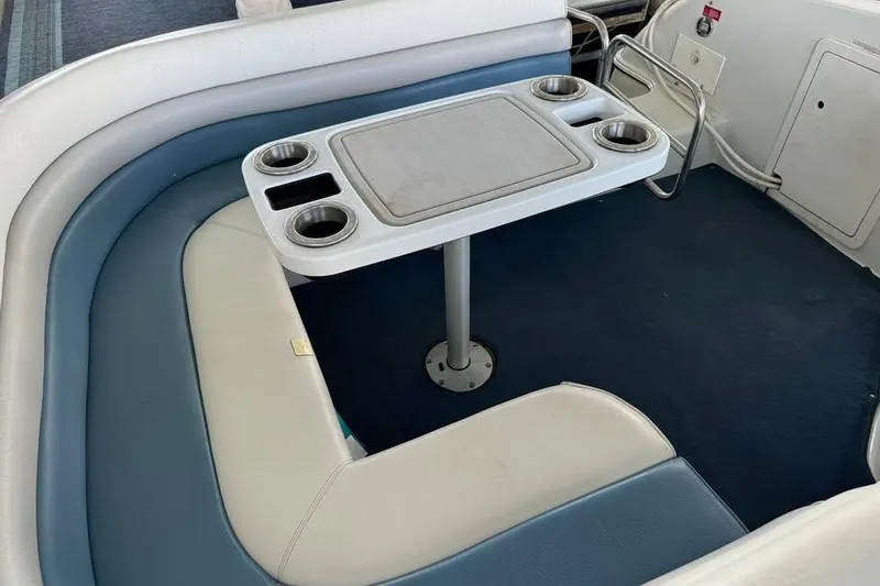 Slide: The Image of 1994 Chris-Craft 322 Crowne boat interior with cushioned seating and table with cup holders. - 14