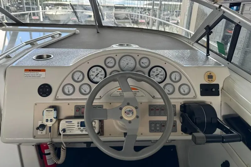 Slide: The Image of 1994 Chris-Craft 322 Crowne boat dashboard with steering wheel and control gauges. - 15
