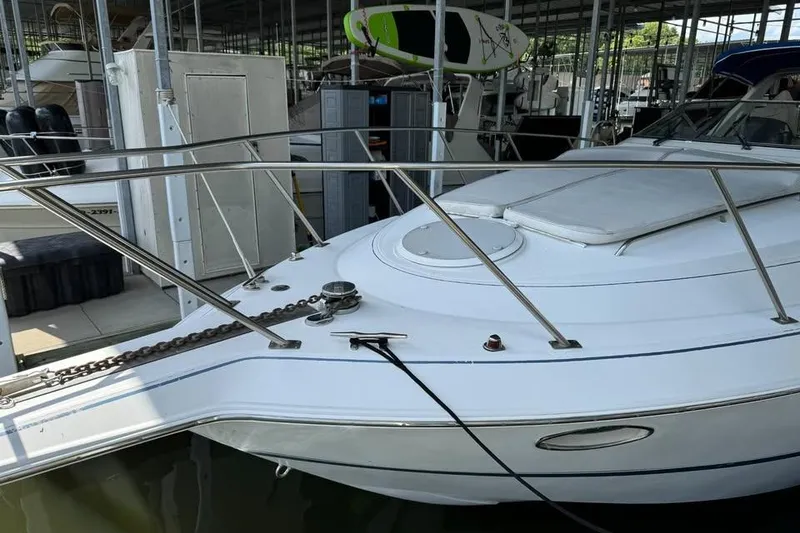 Slide: The Image of 1994 Chris-Craft 322 Crowne boat docked in a marina, featuring sleek white design. - 19
