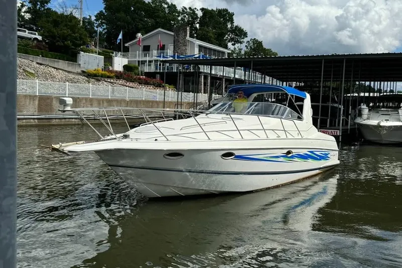 Slide: The Image of 1994 Chris-Craft 322 Crowne boat docked at marina with blue accents and canopy. - 8