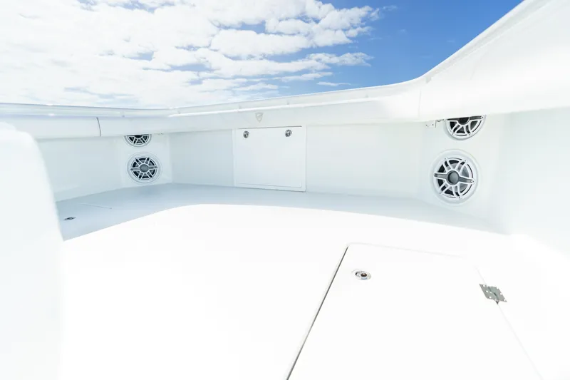 Slide: The Image of 2021 Barker Boatworks 40 HPC interior with speakers, white deck, and blue sky. - 11