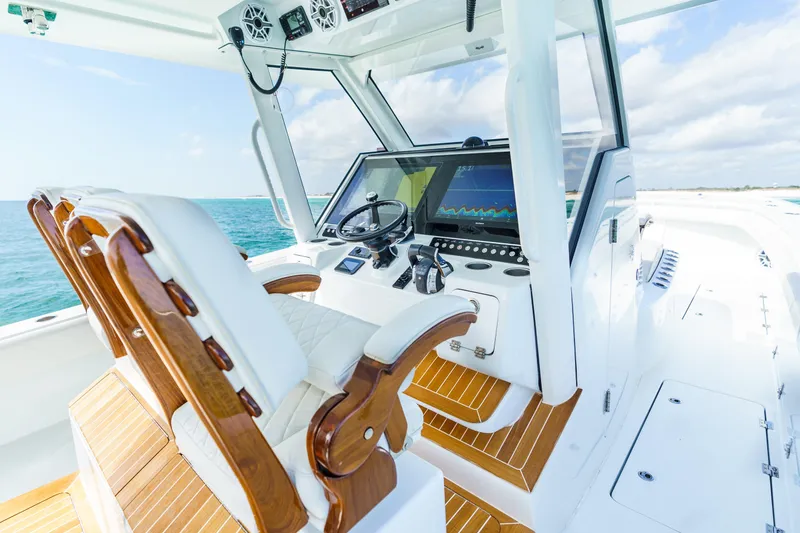 Slide: The Image of 2021 Barker Boatworks 40 HPC helm with luxurious seating and advanced navigation system. - 13