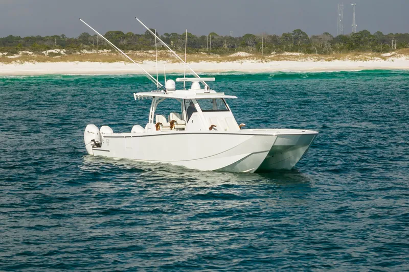 Slide: The Image of 2021 Barker Boatworks 40 HPC cruising on blue ocean near sandy shore. - 4