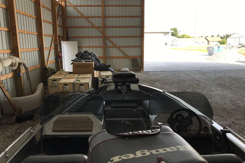 Slide: The Image of 1990 Ranger 375V boat interior with steering mechanism and cushioned seating. - 12