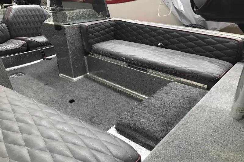 Slide: The Image of Interior of a 1990 Ranger 375V boat with quilted gray seating and carpeted flooring. - 14