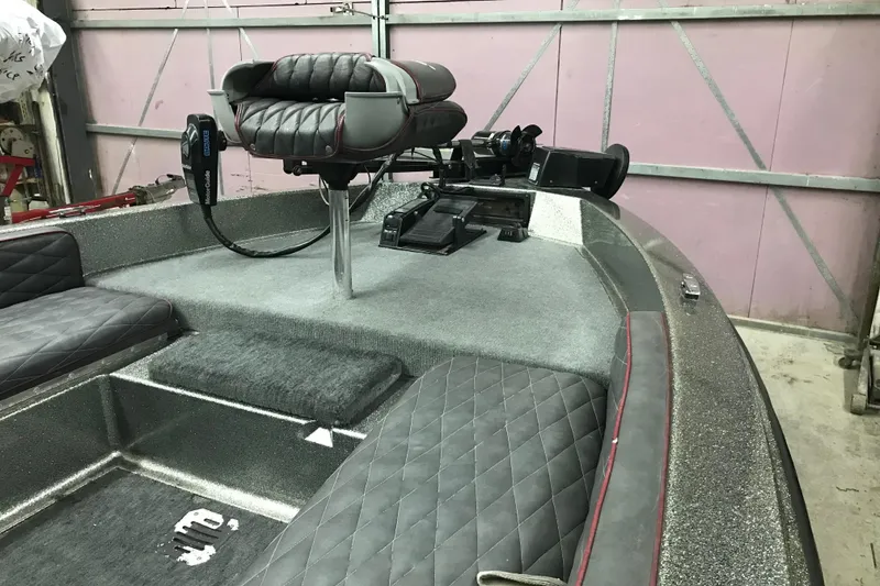 Slide: The Image of 1990 Ranger 375V boat interior with gray quilted seats and fishing equipment. - 15