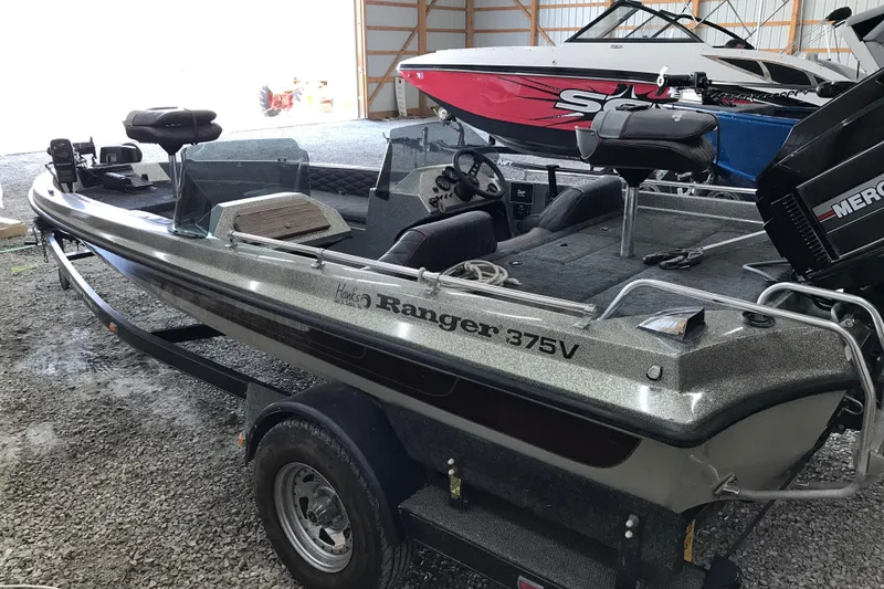 Slide: The Image of 1990 Ranger 375V boat in storage, featuring a sleek design and Mercury outboard motor. - 3