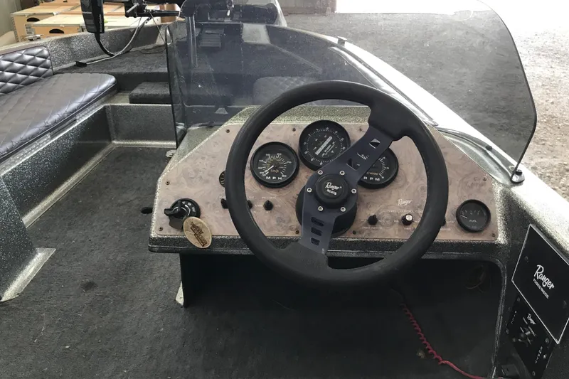 Slide: The Image of 1990 Ranger 375V boat dashboard with steering wheel and gauges. - 7