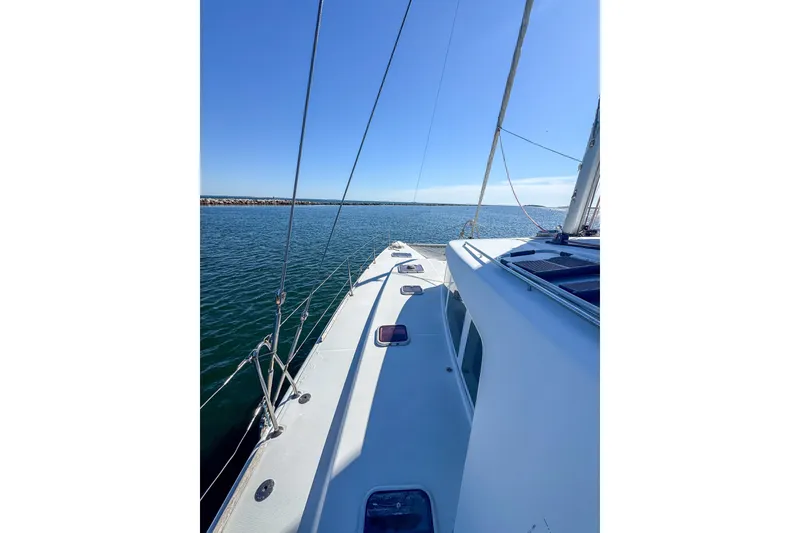 Slide: The Image of 2005 Lagoon 440 catamaran sailing on calm waters under clear blue skies. - 12