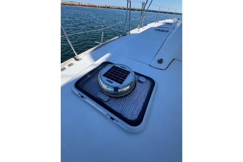 Slide: The Image of Deck view of 2005 Lagoon 440 catamaran with solar vent, near water. - 13