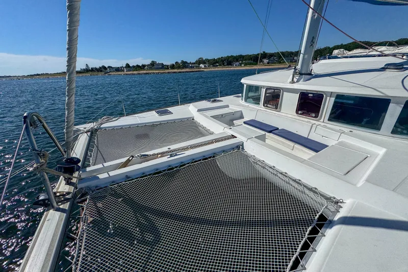 Slide: The Image of 2005 Lagoon 440 catamaran on calm waters, featuring spacious deck and netting. - 15