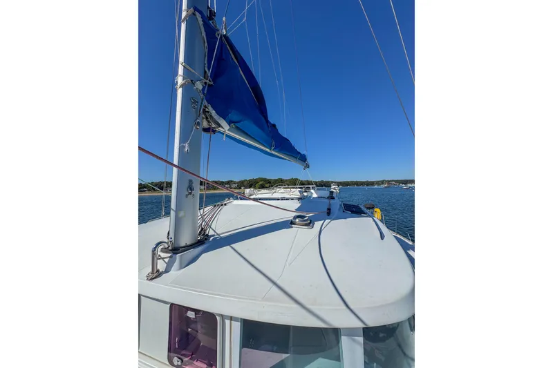 Slide: The Image of 2005 Lagoon 440 sailboat with blue sail, anchored on a sunny day. - 17