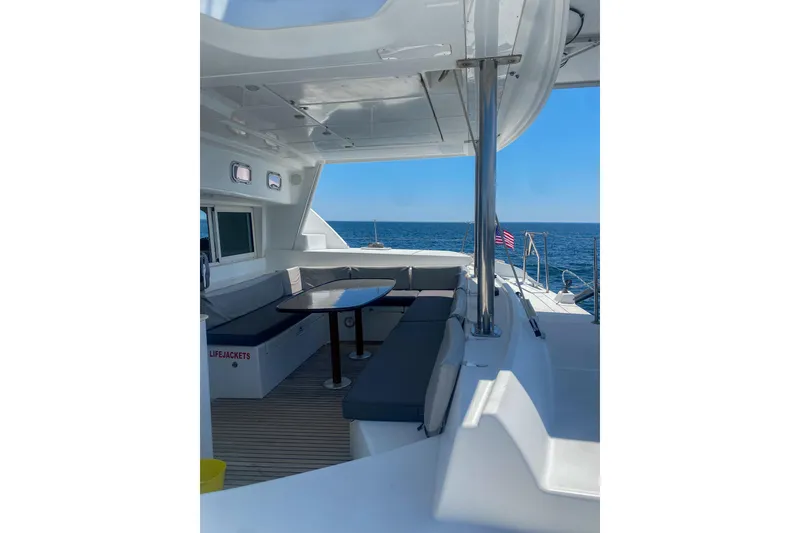 Slide: The Image of 2005 Lagoon 440 catamaran interior with seating area, table, and ocean view. - 18