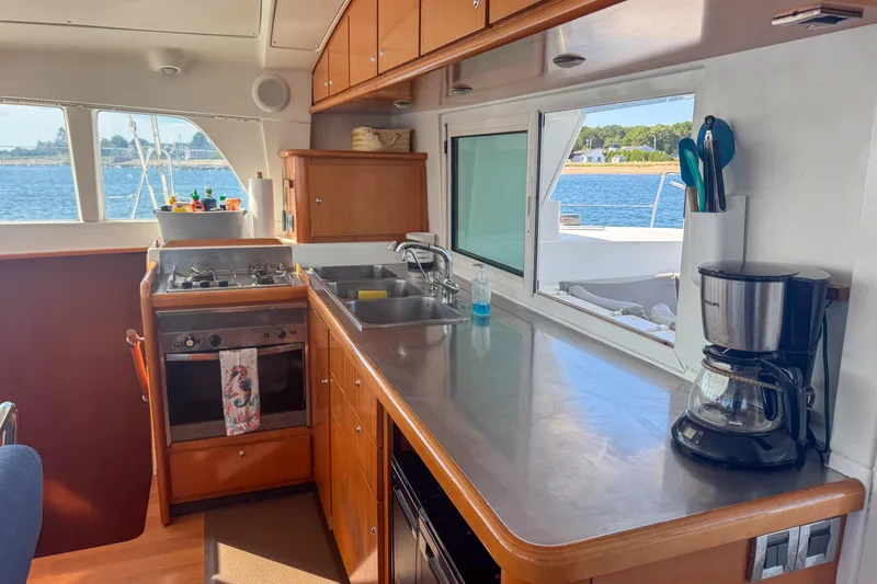 Slide: The Image of Interior of 2005 Lagoon 440 catamaran kitchen with stove, sink, and coffee maker. - 23
