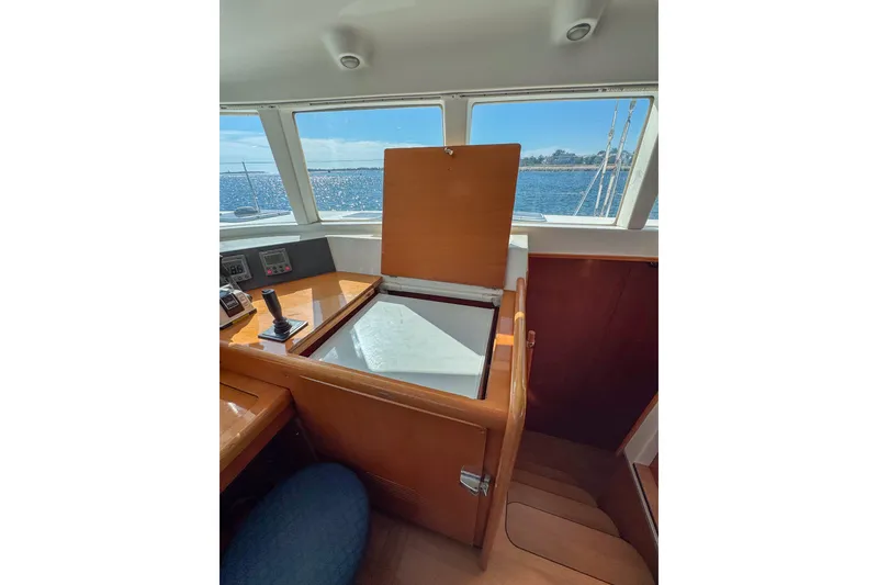 Slide: The Image of Interior of 2005 Lagoon 440 yacht with open storage compartment and ocean view. - 28