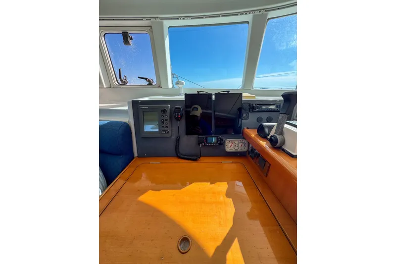 Slide: The Image of Cockpit of 2005 Lagoon 440 catamaran with navigation equipment and wooden table. - 33