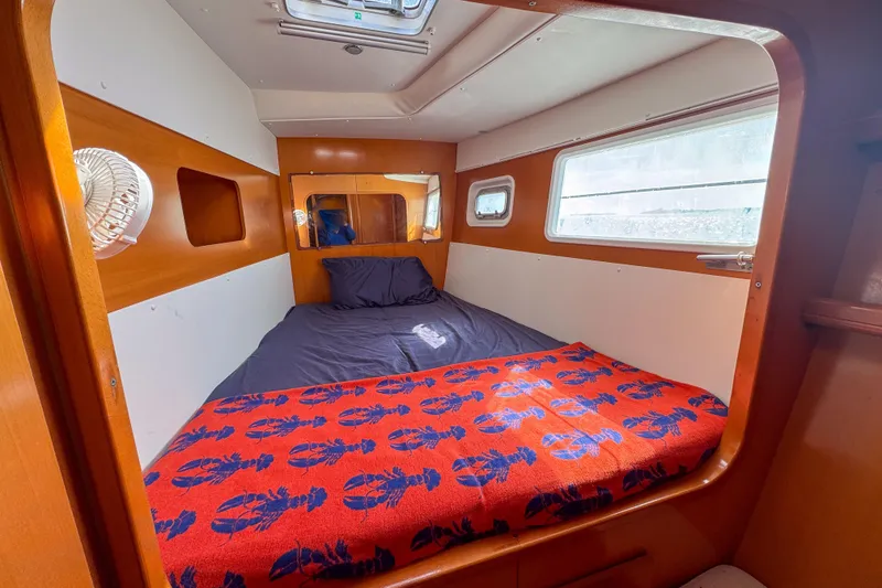 Slide: The Image of Cozy cabin interior of 2005 Lagoon 440 catamaran with bed and window. - 38