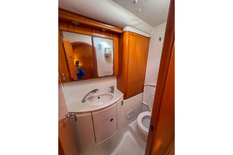 Slide: The Image of Bathroom interior of 2005 Lagoon 440 yacht, featuring wooden cabinetry and compact design. - 39