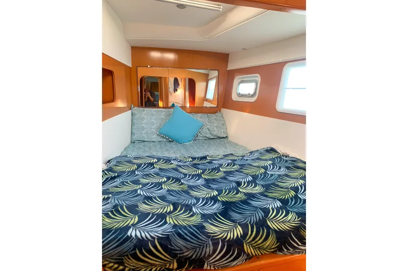 Slide: The Image of Cozy cabin interior of 2005 Lagoon 440 catamaran with patterned bedding and porthole windows. - 44