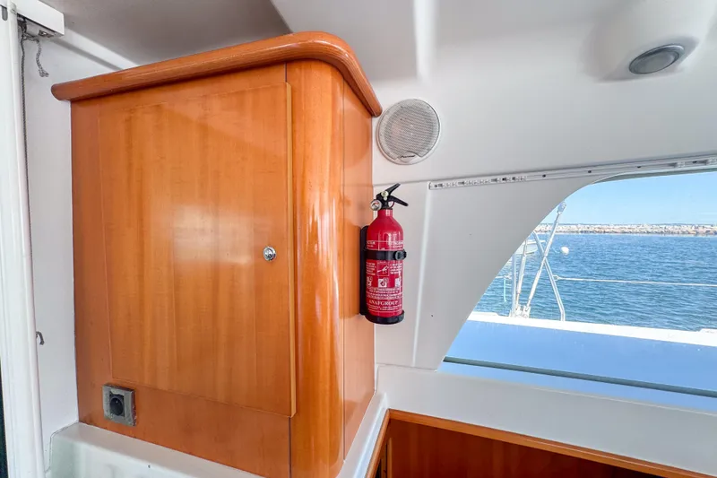 Slide: The Image of Interior of 2005 Lagoon 440 yacht with wooden cabinet and fire extinguisher. - 46