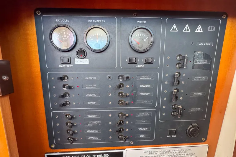 Slide: The Image of Electrical control panel of a 2005 Lagoon 440 catamaran, featuring gauges and switches. - 48