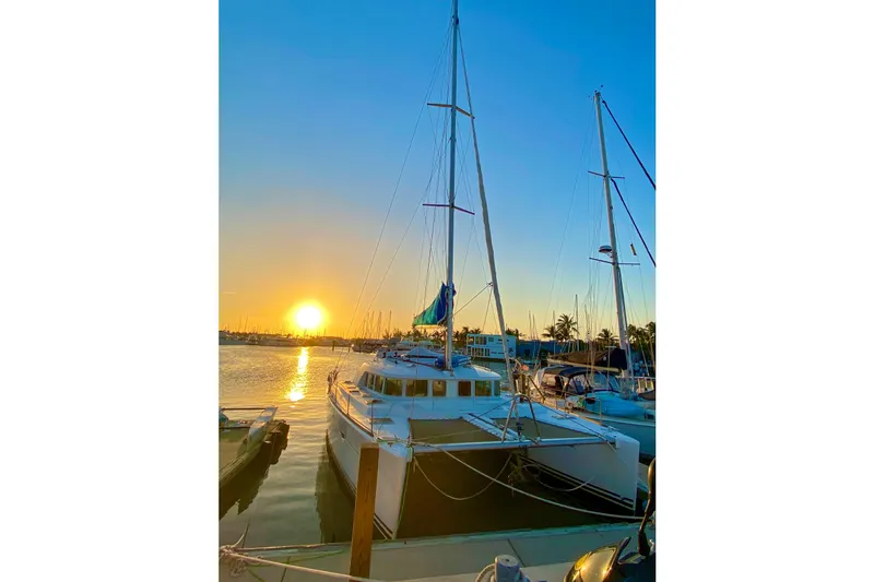 Slide: The Image of Lagoon 440 catamaran docked at sunset, 2005 model, serene marina view. - 52