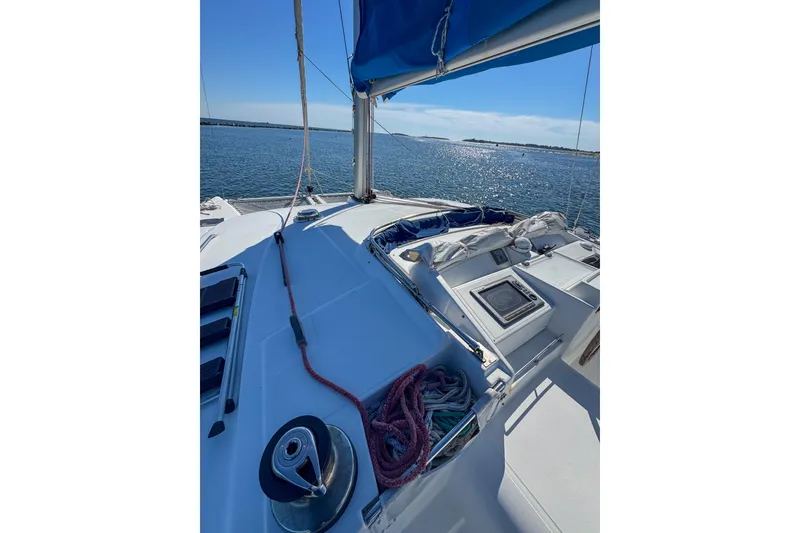 Slide: The Image of Catamaran deck view, Lagoon 440, 2005 model, sailing on calm waters under clear blue sky. - 6