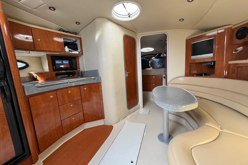 Slide: The Image of Interior of a 2006 Larson 3700 Cabrio boat with wood cabinetry and seating area. - 13