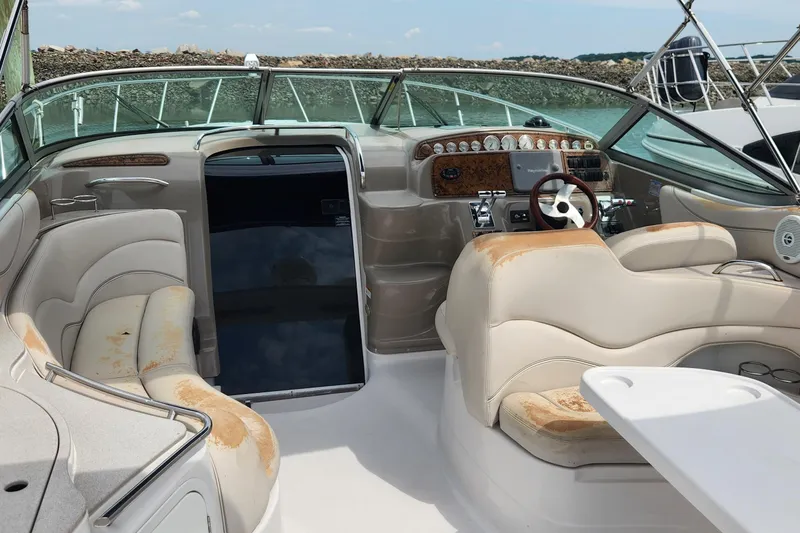 Slide: The Image of 2006 Larson 3700 Cabrio boat interior with beige seating and control panel. - 3