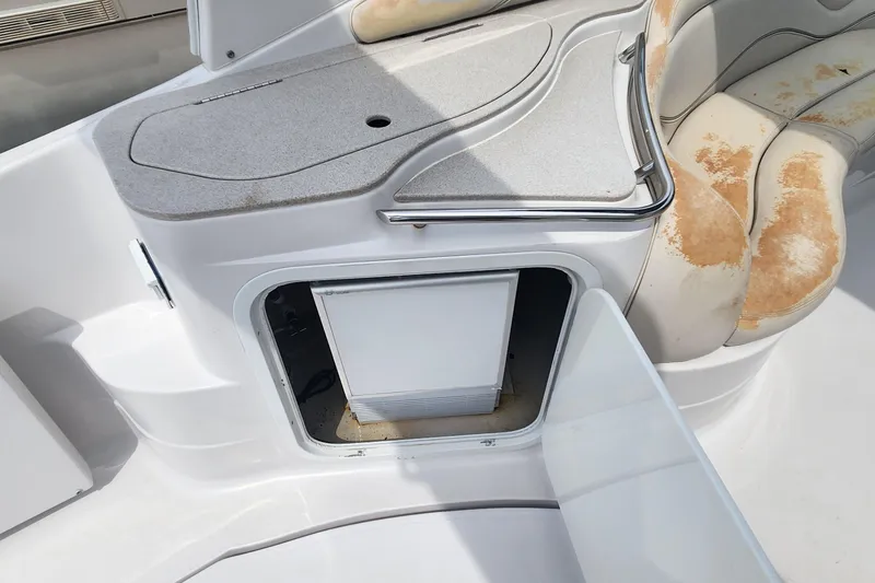Slide: The Image of 2006 Larson 3700 Cabrio boat interior with storage compartment and worn seating. - 5